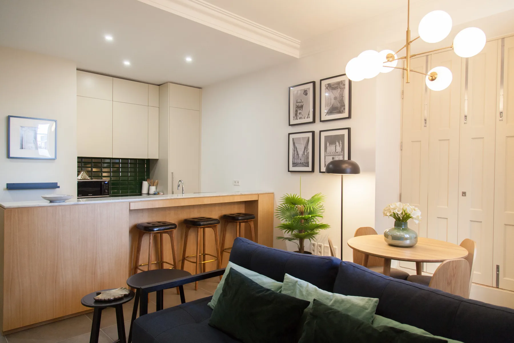 Una luminosa sala-comedor de planta abierta con barra de cocina y asientos.