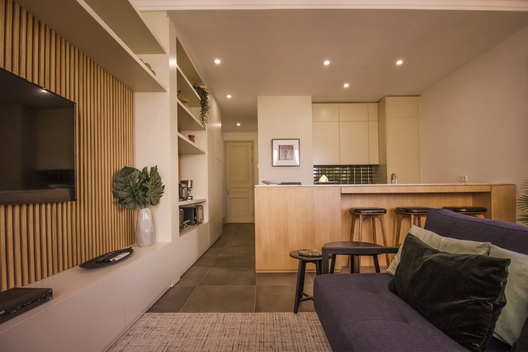 Salón y cocina de concepto abierto con un sofá y una barra.