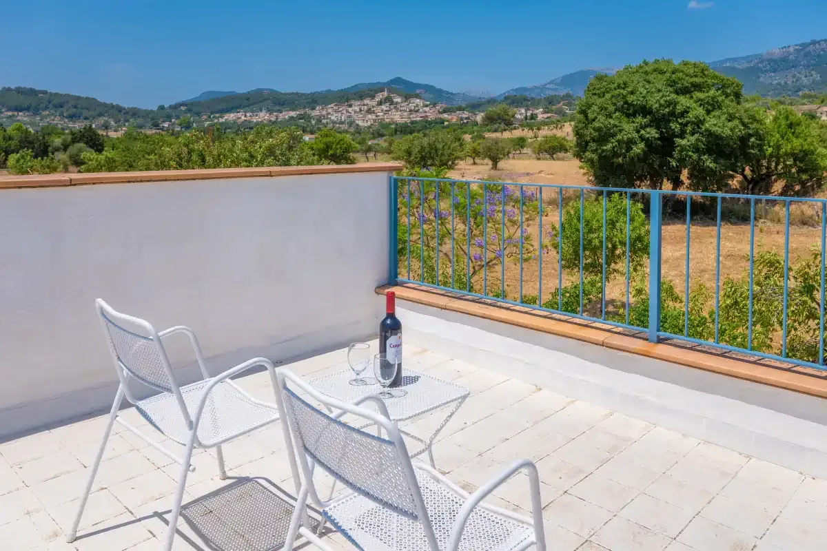 A tiled terrace with seating overlooks fields and distant hills.