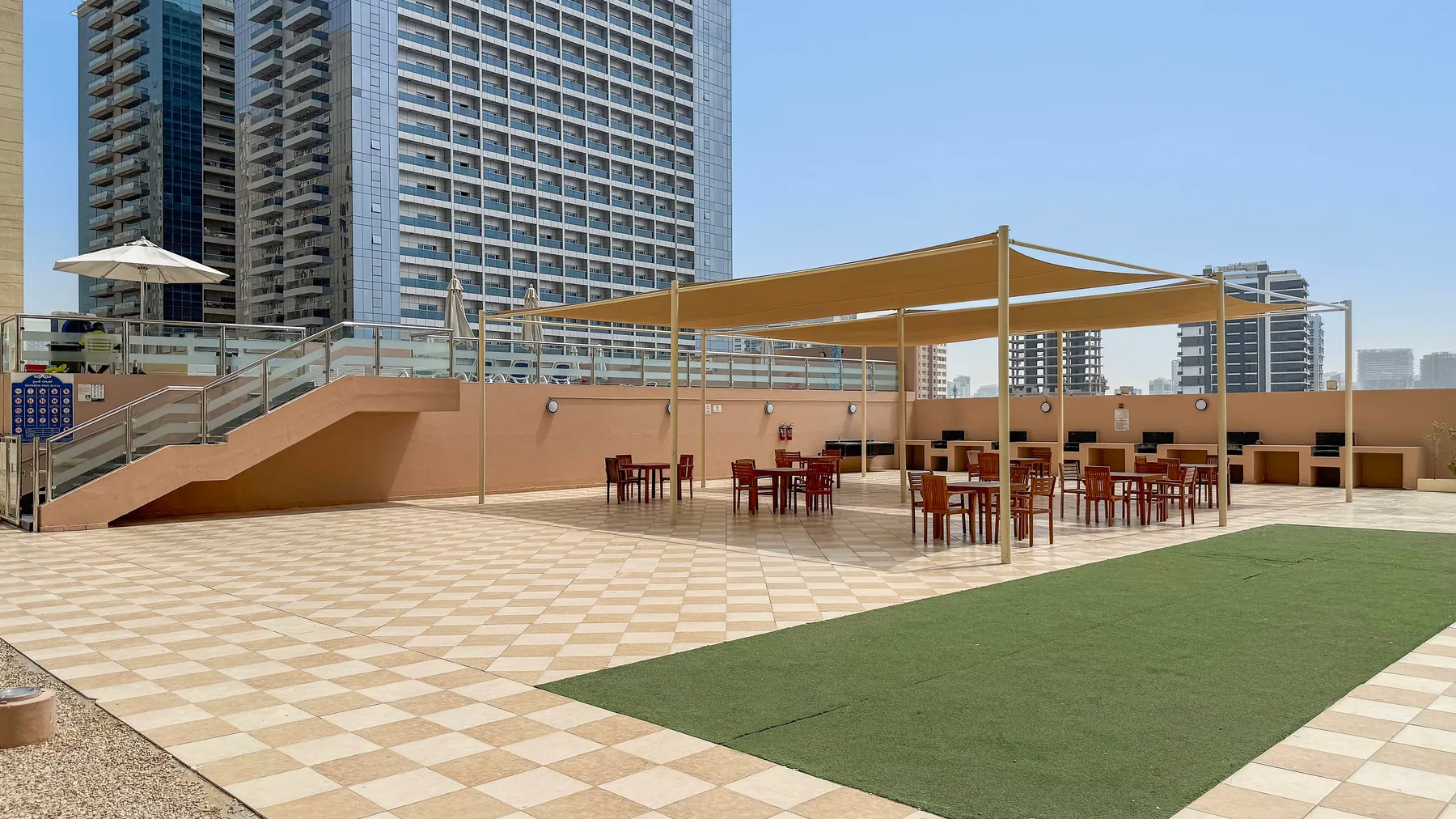 A rooftop terrace with outdoor seating beneath a shade canopy.
