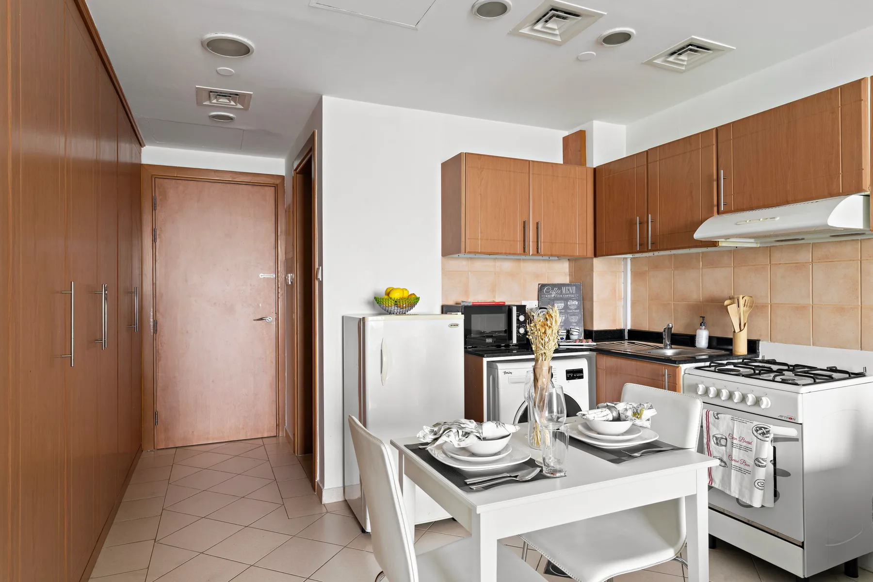 A kitchen with wood cabinets, a stove, and a dining table.