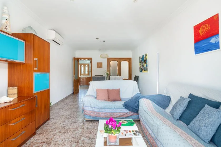 A bright living room with two seating areas and a coffee table.