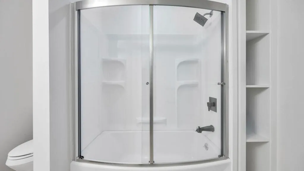 Una ducha de baño con puertas de vidrio y estantes empotrados.