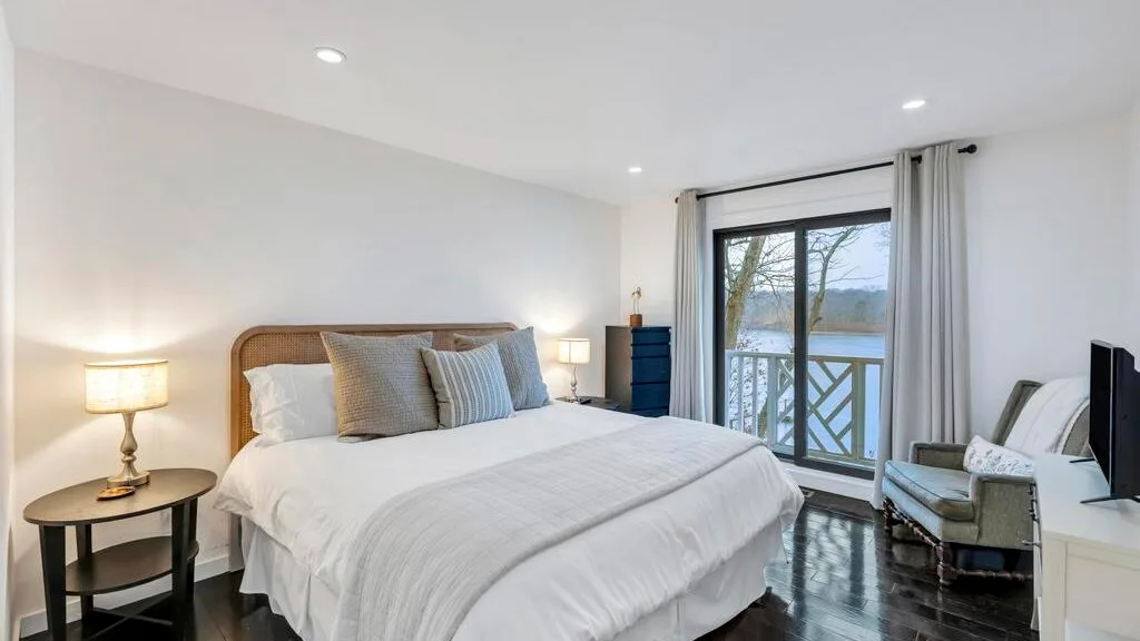 Un dormitorio con una cama grande y una puerta de vidrio que da a un balcón.
