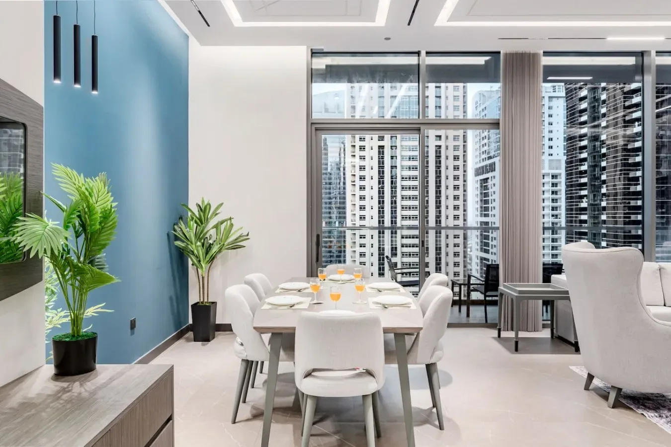Un comedor moderno con una mesa y asientos junto a grandes ventanales.
