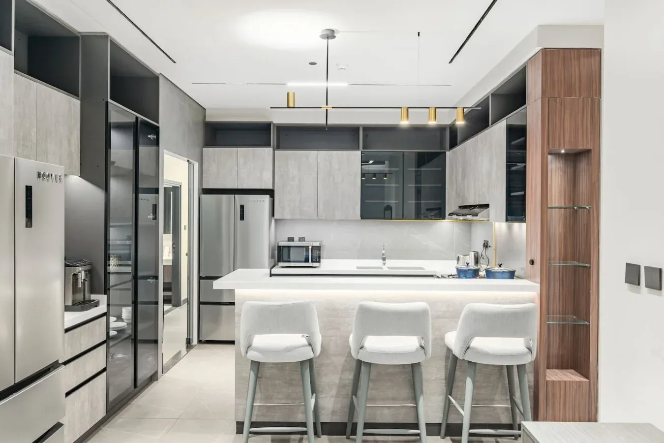 Una cocina moderna con una isla central y tres taburetes.