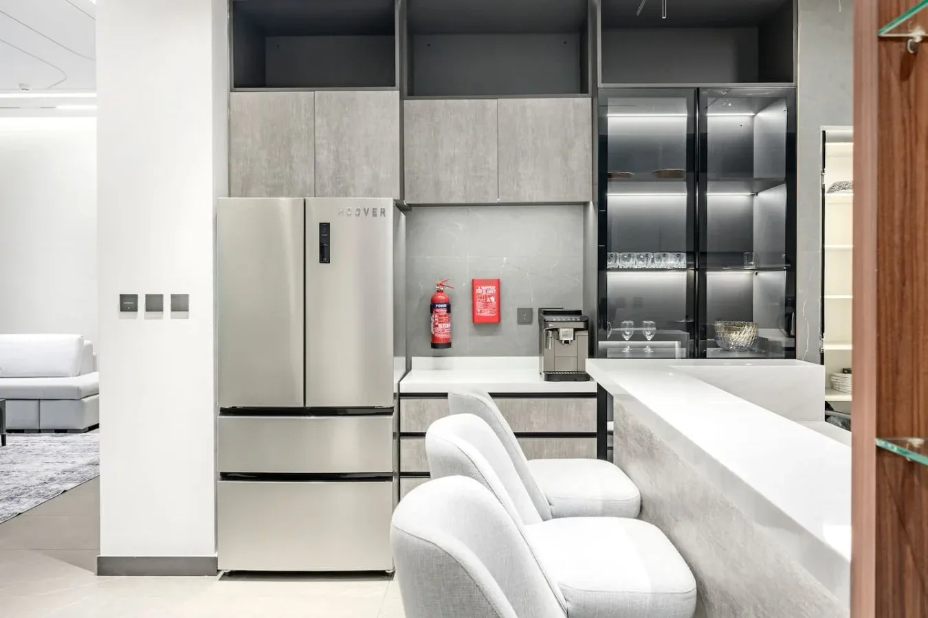 Una cocina moderna con refrigerador, encimera y asientos acolchados.