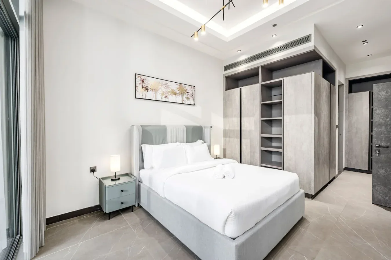 Un dormitorio luminoso con una cama bien arreglada y armarios empotrados.