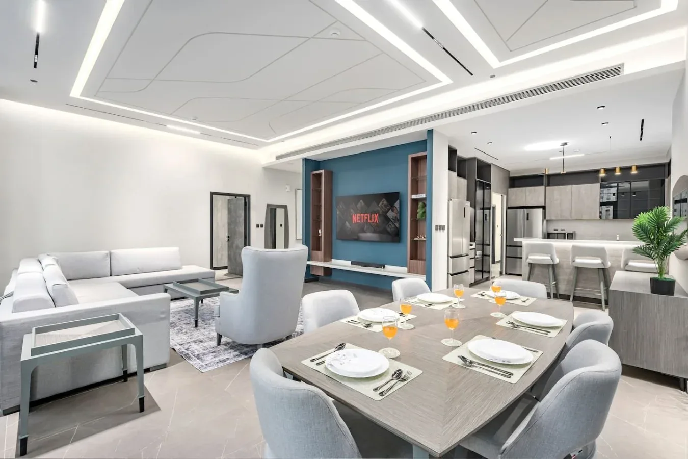 Una moderna sala-comedor de planta abierta con la cocina al fondo.