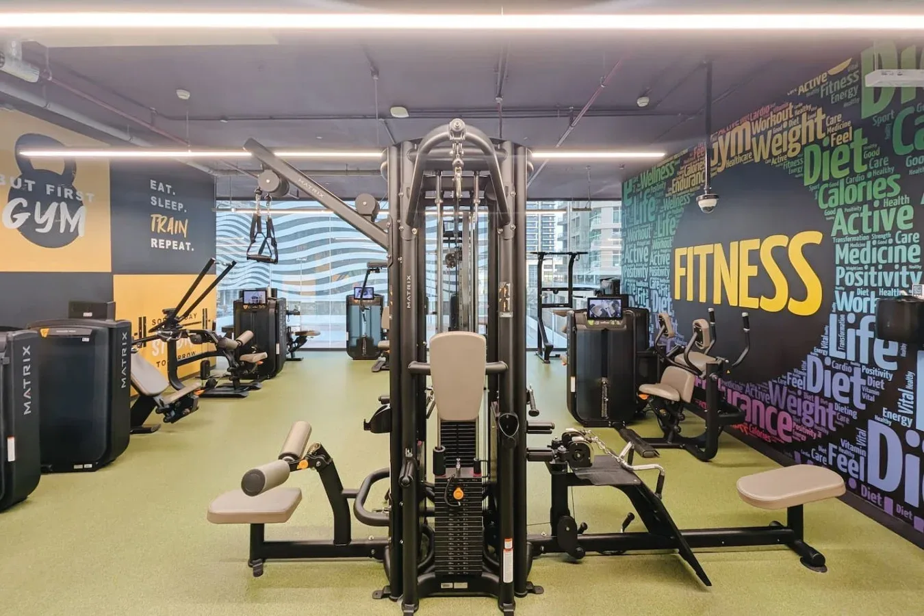 Un gimnasio con máquinas de ejercicio y equipo de entrenamiento con pesas.