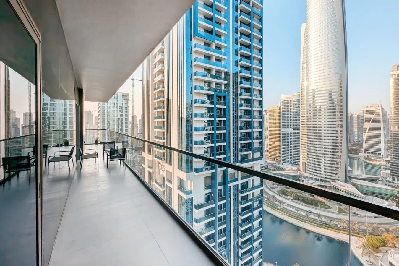 Un balcón en un edificio alto ofrece vistas de edificios modernos y una zona junto al agua.