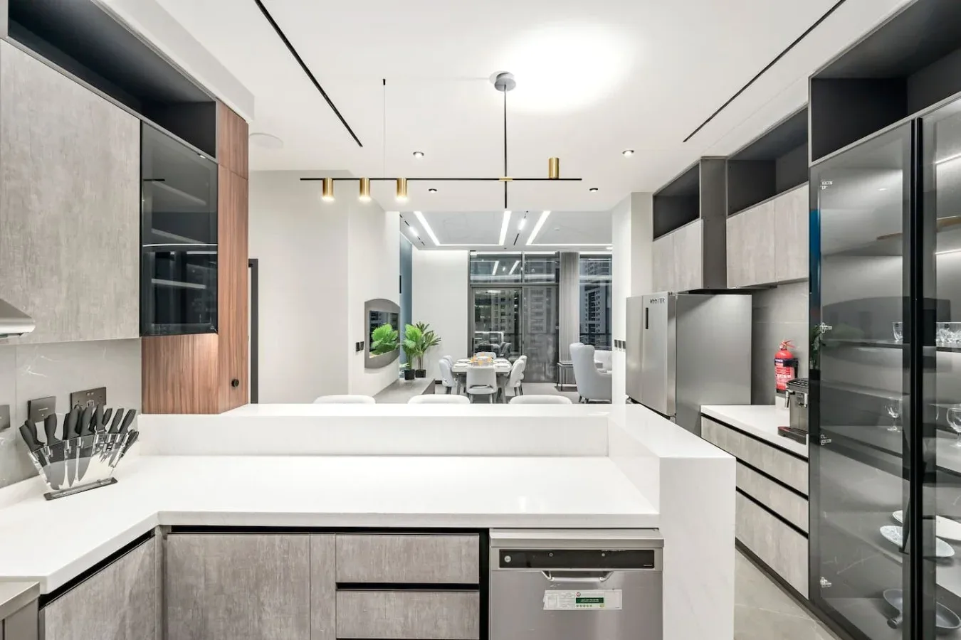 Una cocina moderna con una encimera blanca y electrodomésticos integrados.