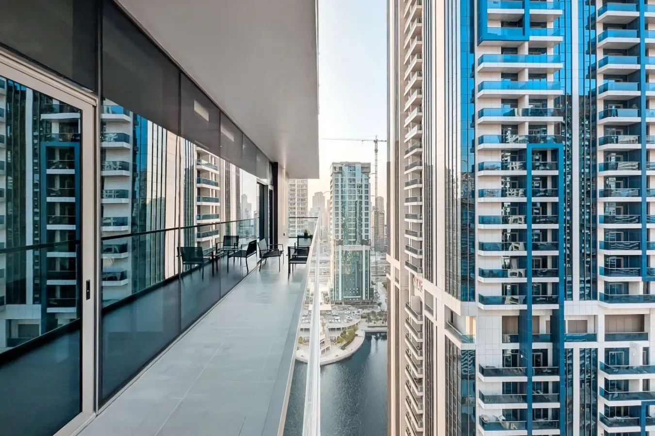 Un balcón de un edificio alto da a torres residenciales cercanas y un canal.