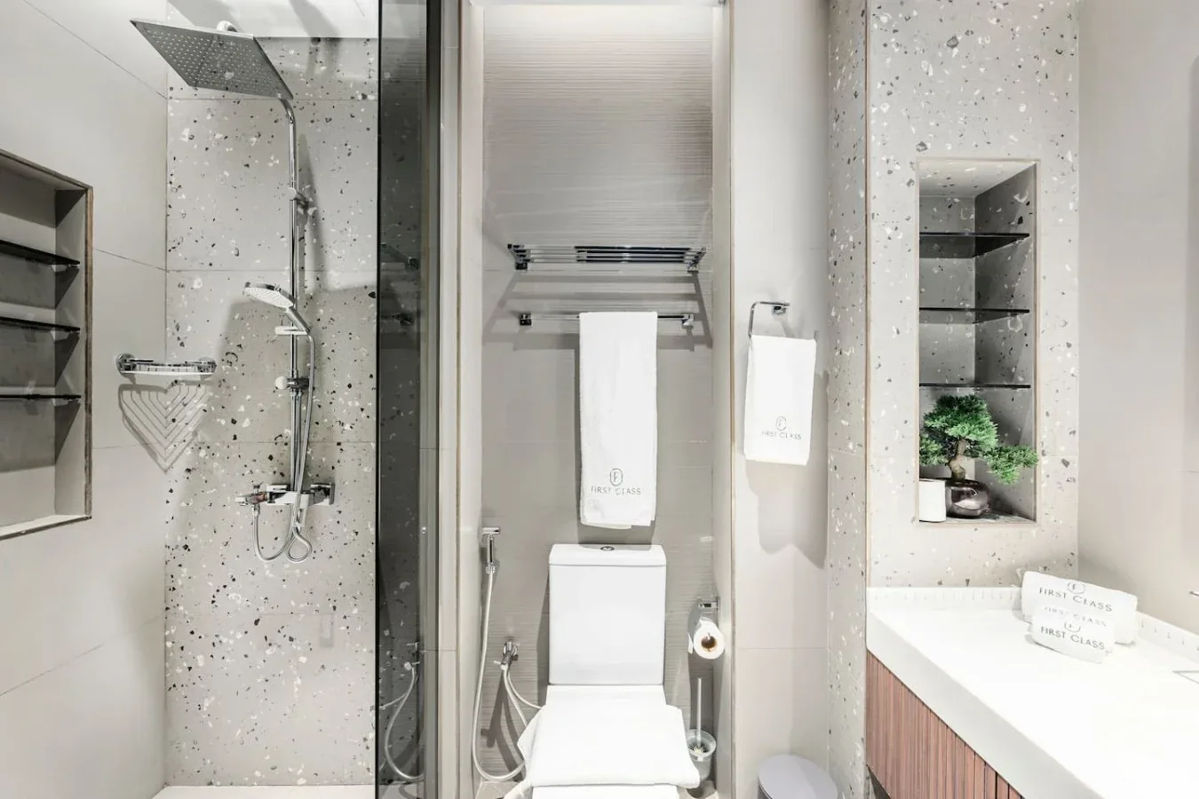 Un baño luminoso con ducha, inodoro y lavabo.