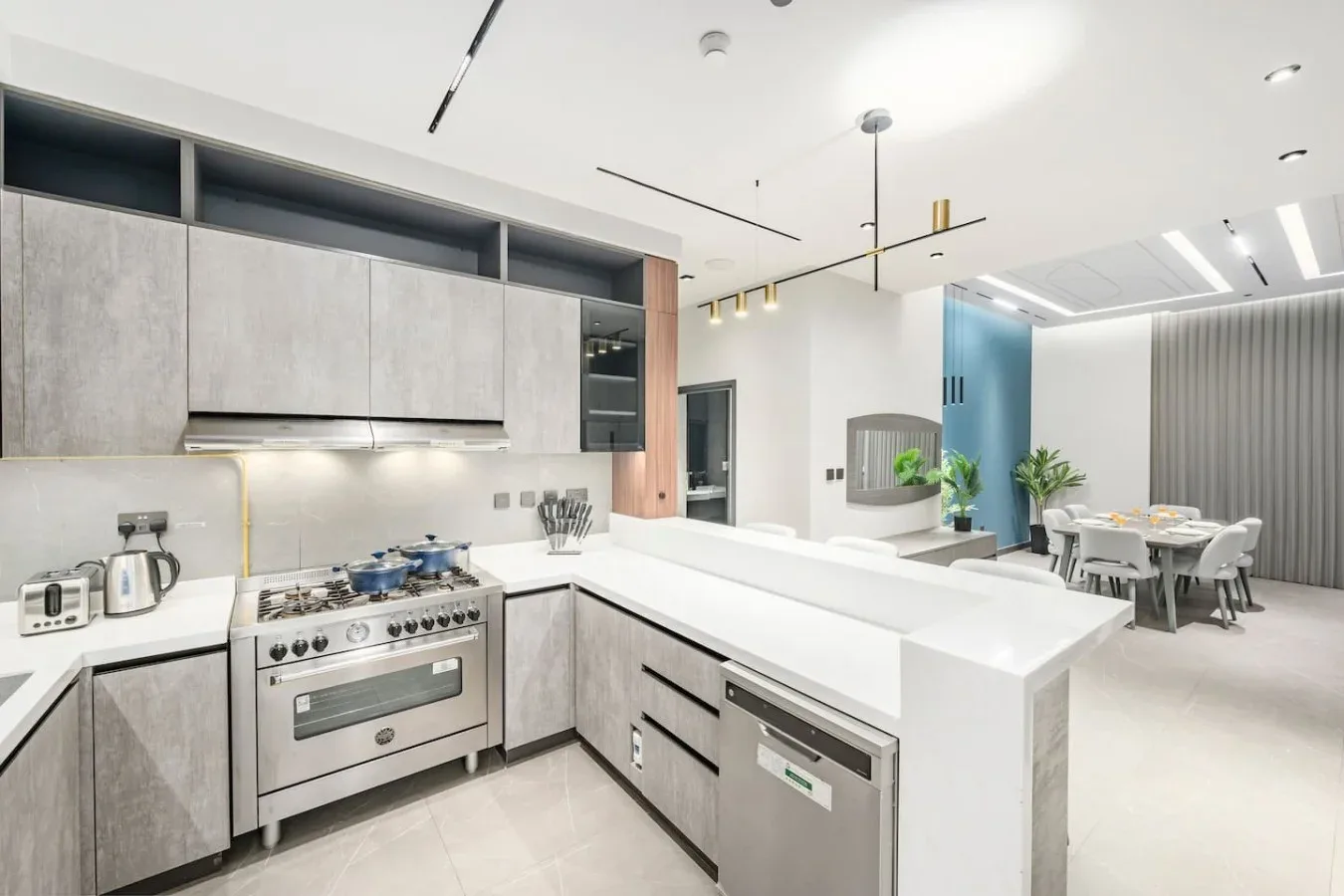 Una cocina moderna con una estufa de acero inoxidable y una isla blanca.