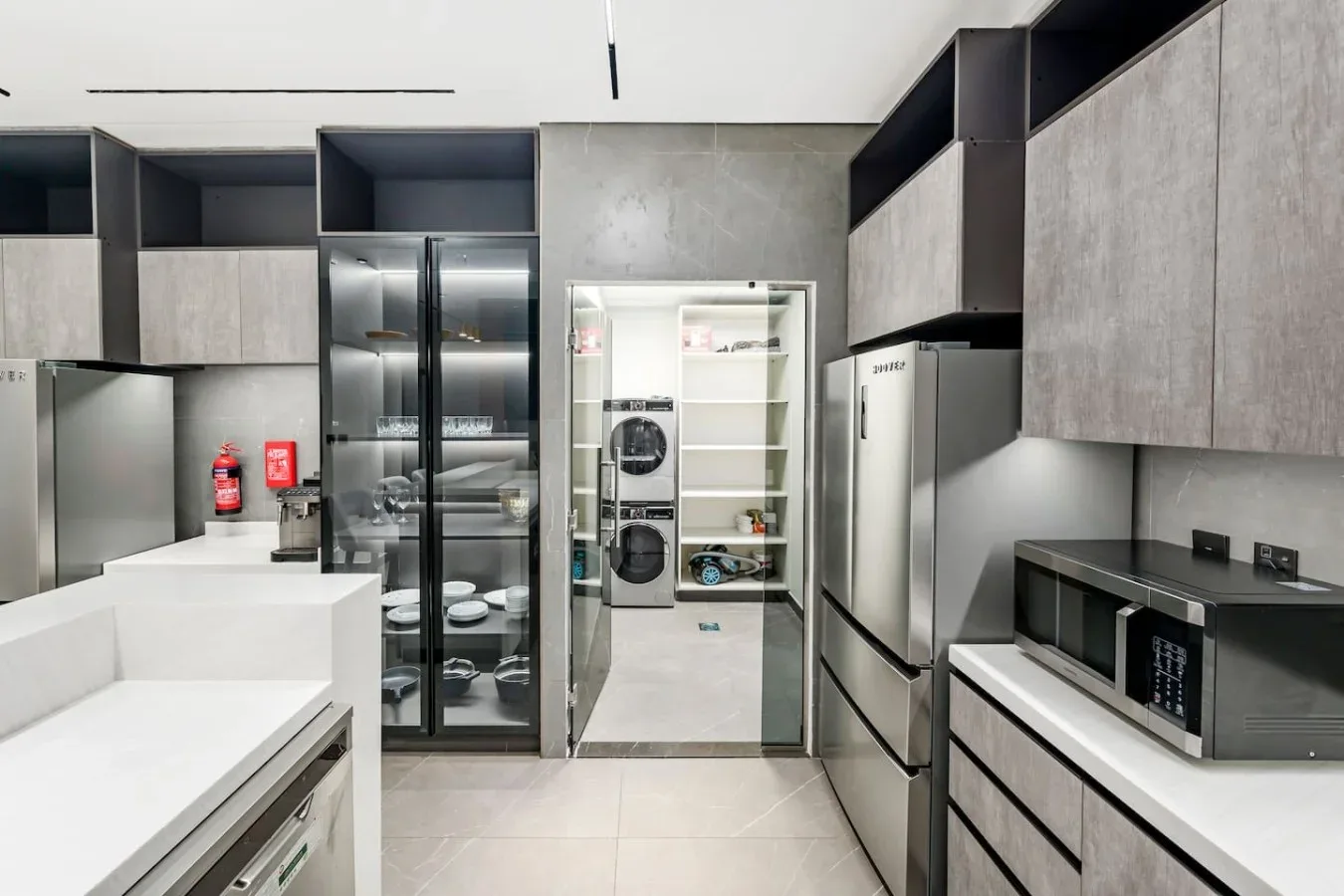 Una cocina moderna con gabinetes oscuros, una isla central y electrodomésticos integrados.