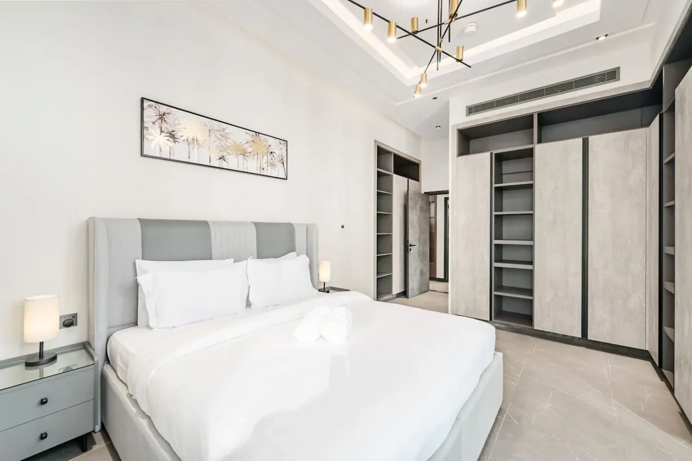 Un dormitorio moderno con una cama bien tendida y armarios empotrados.