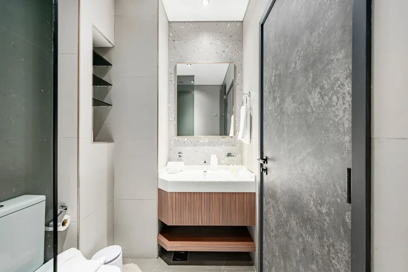 Un baño moderno con lavabo, espejo y ducha.
