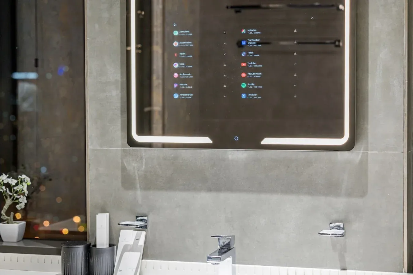 Un lavabo de baño moderno con un gran espejo iluminado y un fregadero.