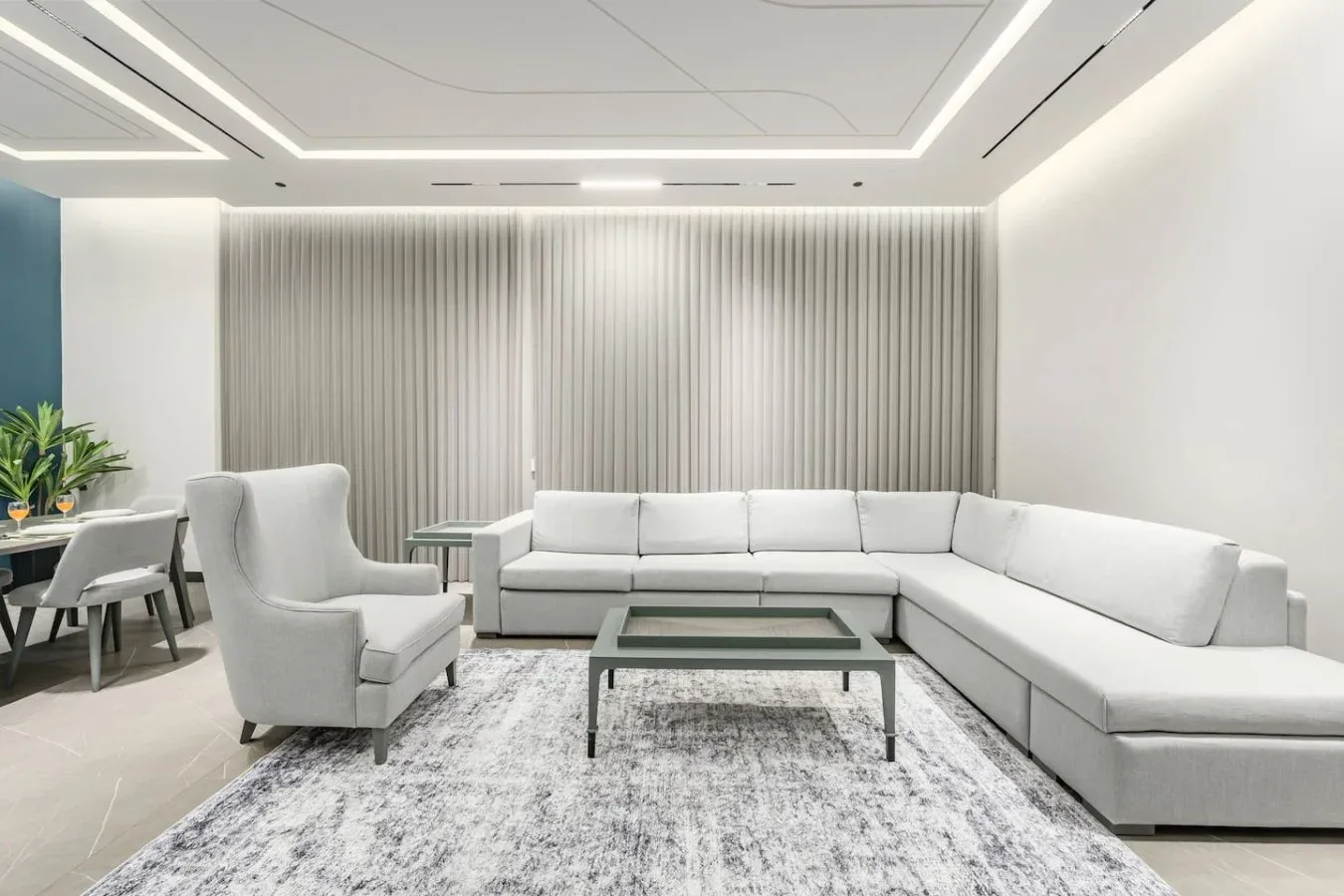 Una sala luminosa con un sofá seccional y una mesa de centro de vidrio.