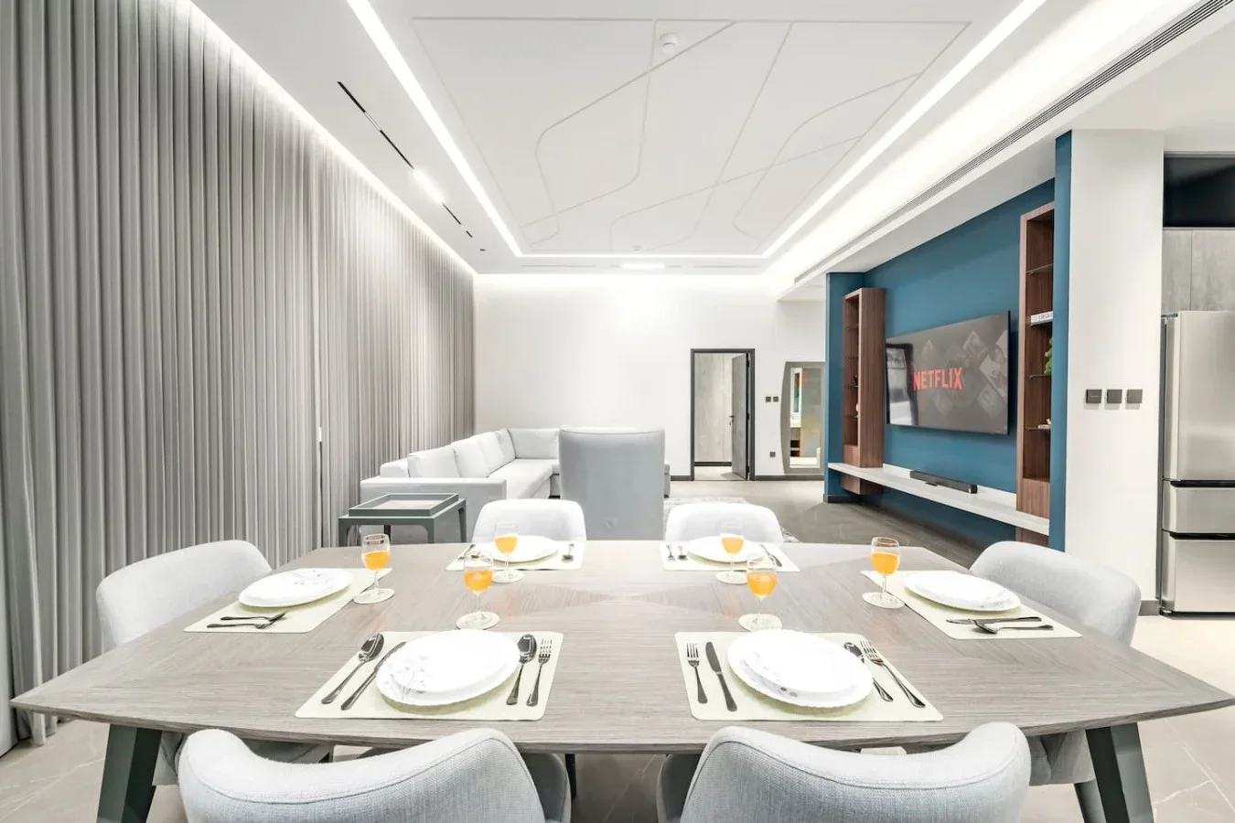 Un comedor con la mesa puesta y un televisor grande en la pared.