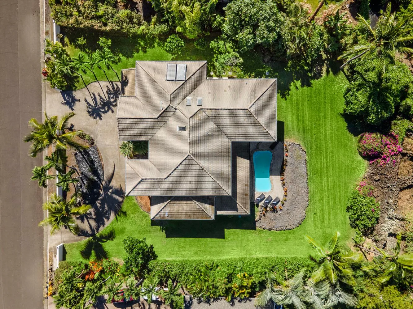Aerial view of a house with a swimming pool and surrounding garden.