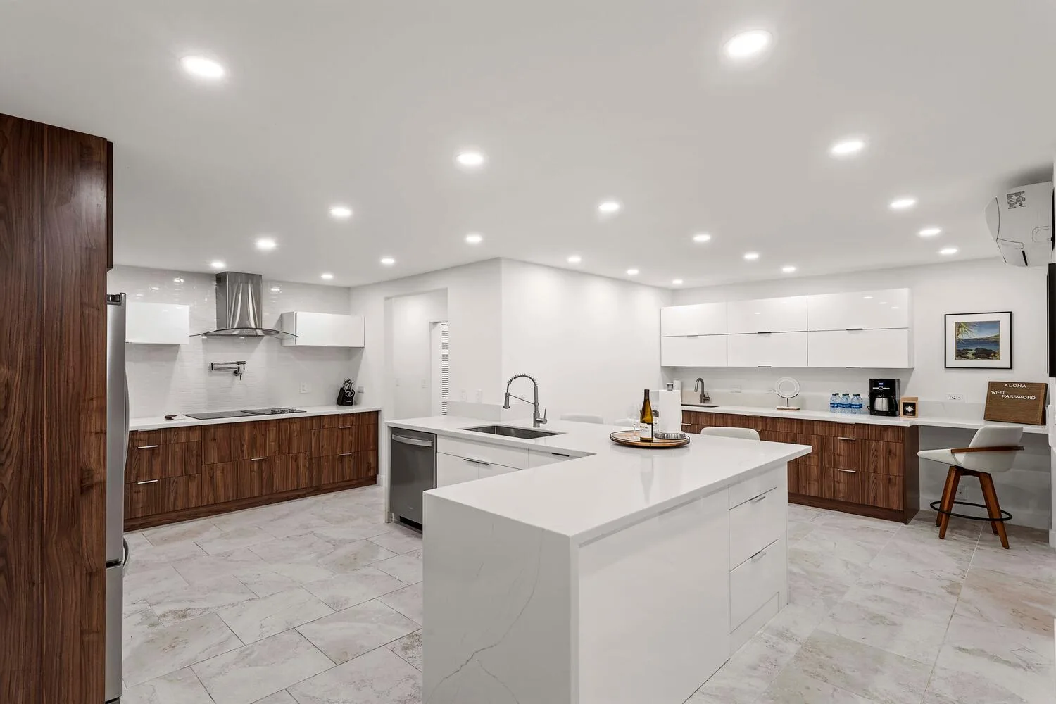 A bright modern kitchen with white counters and dark wood cabinets.