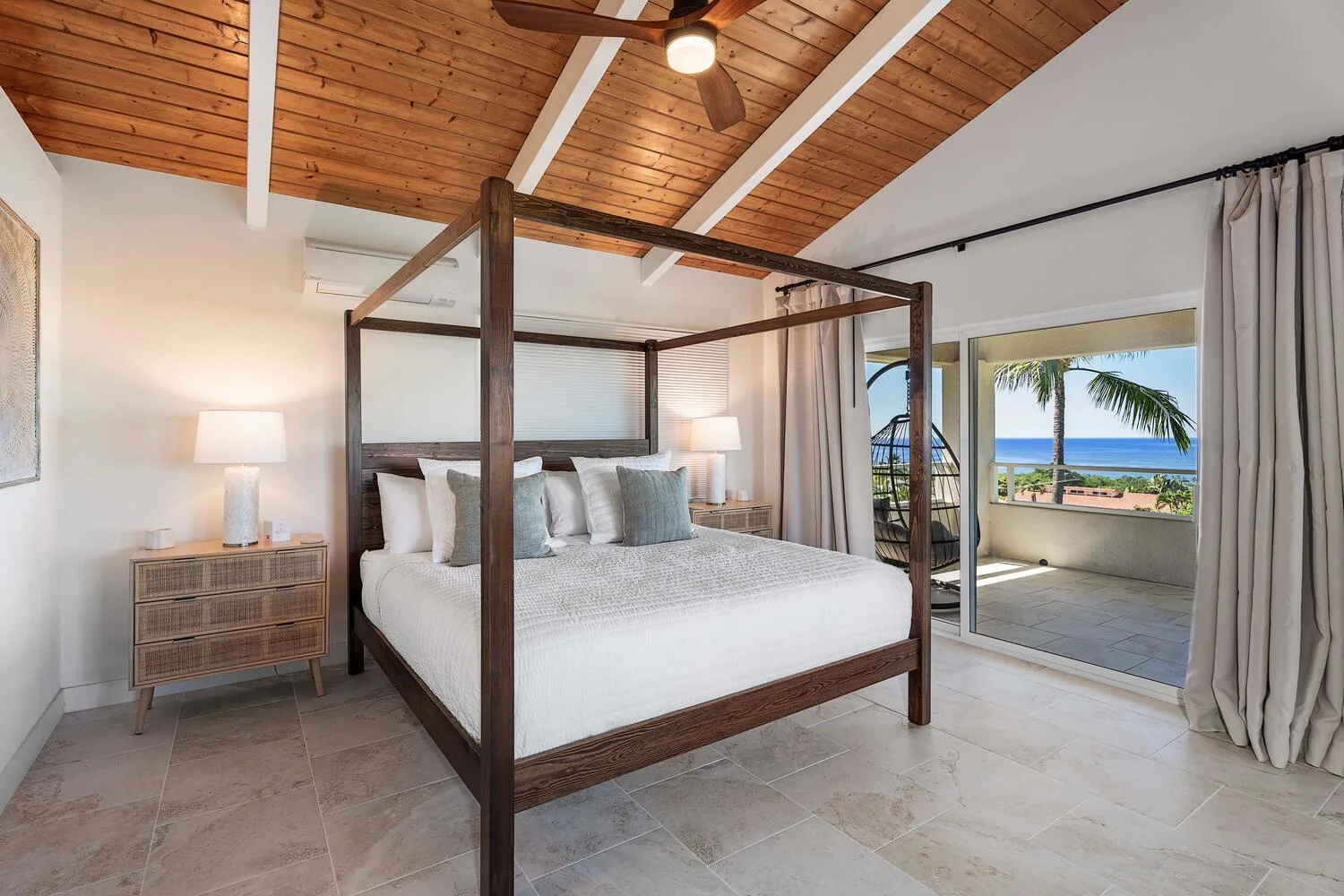 A bedroom with a four-poster bed and sliding doors opening onto a balcony.
