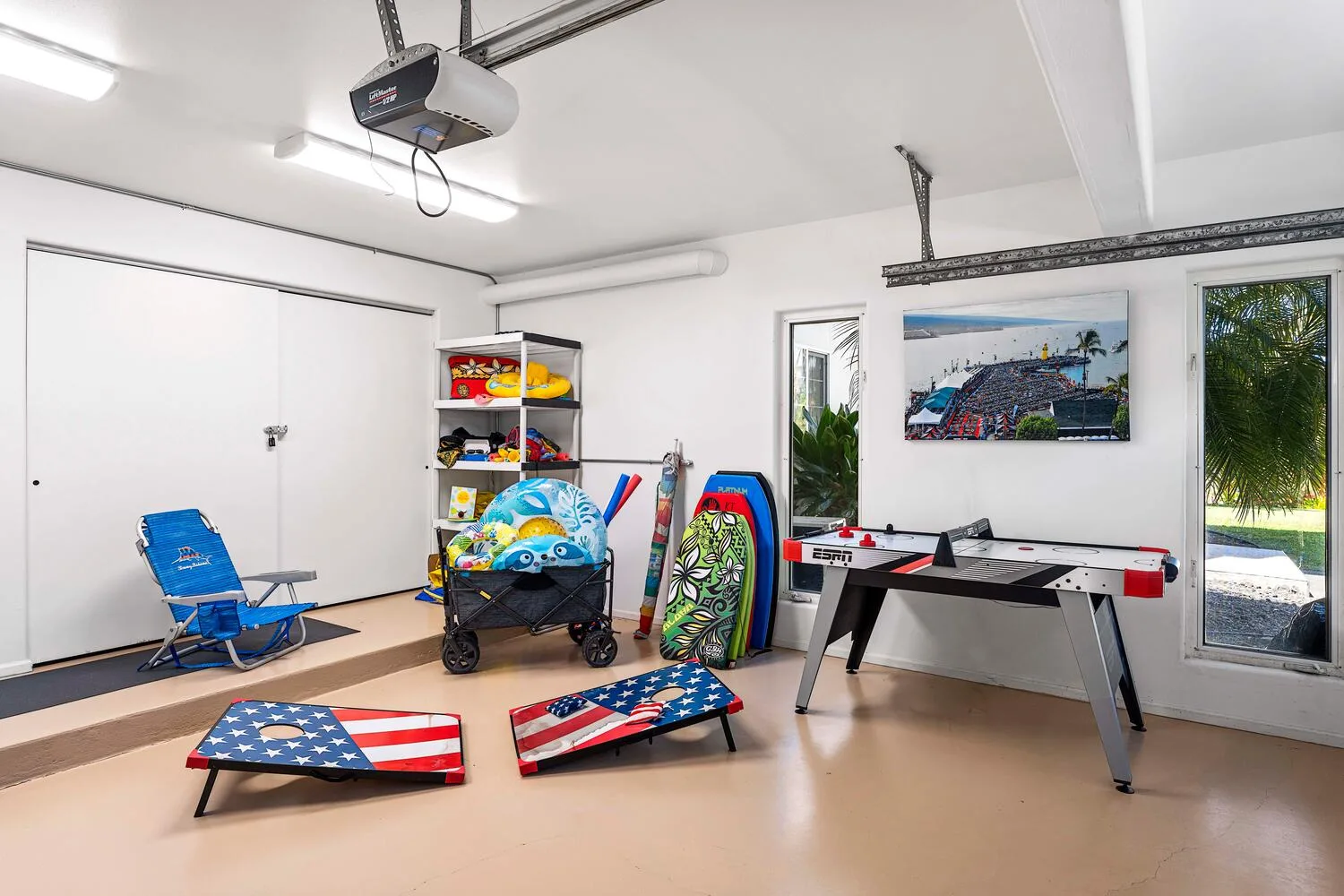 A recreation room with a foosball table, cornhole boards, and outdoor gear.