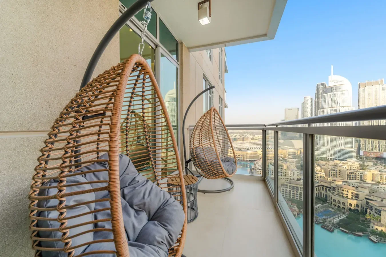 Un balcón con asientos colgantes ofrece vistas del horizonte urbano y el agua.