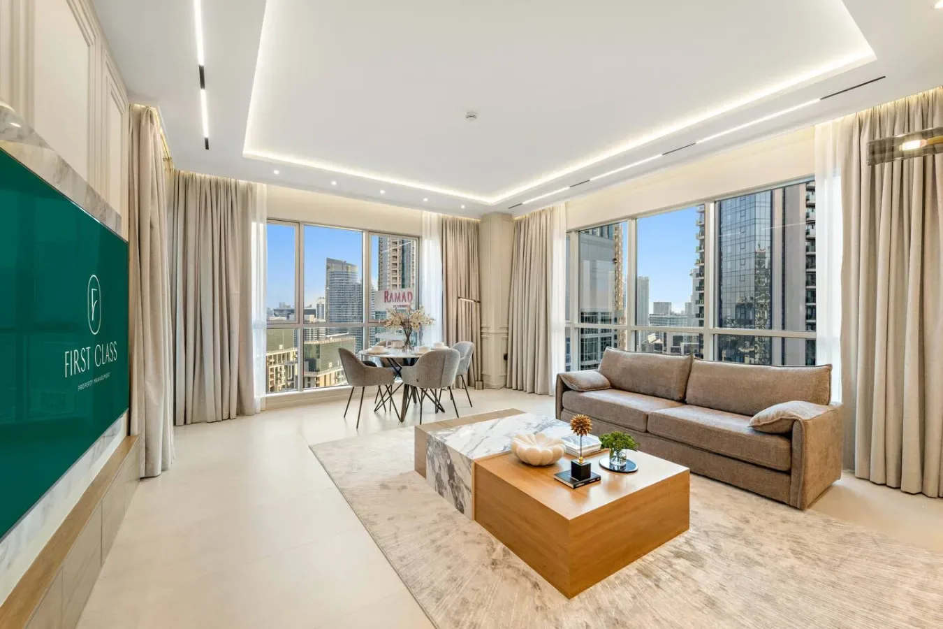 Una sala luminosa con asientos y un comedor junto a grandes ventanales.