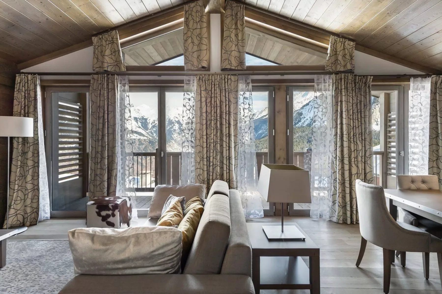 A bright living room with seating and large windows overlooking a mountain view.