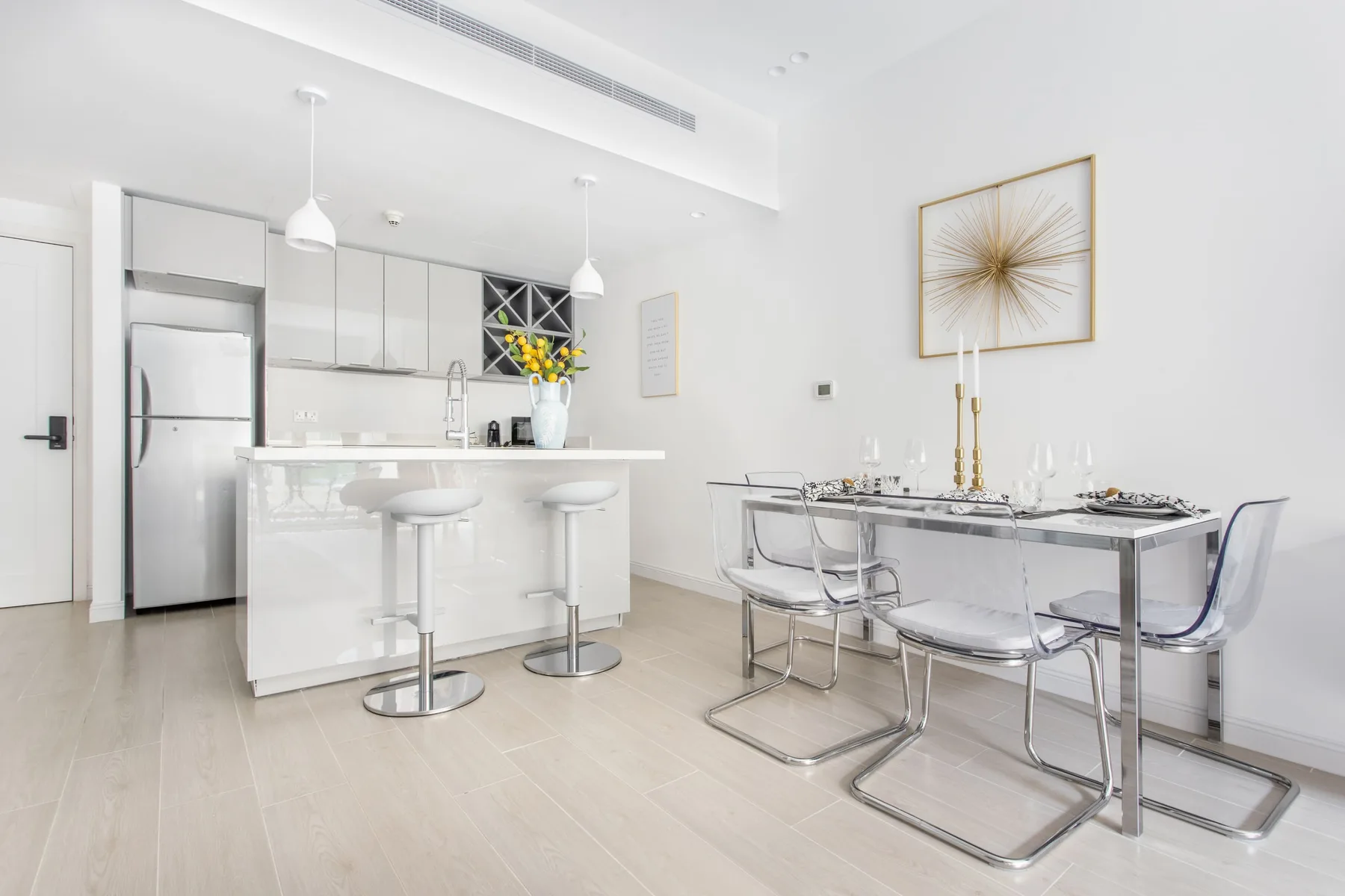 Un comedor luminoso con una mesa y una isla de cocina con asientos.