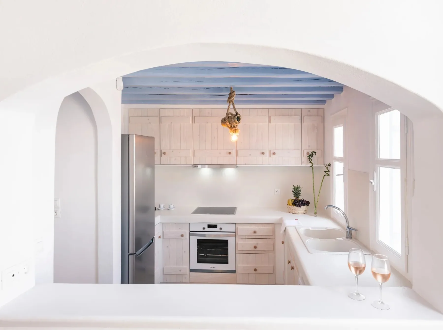 Una cocina luminosa con gabinetes claros, un horno empotrado y una encimera amplia.