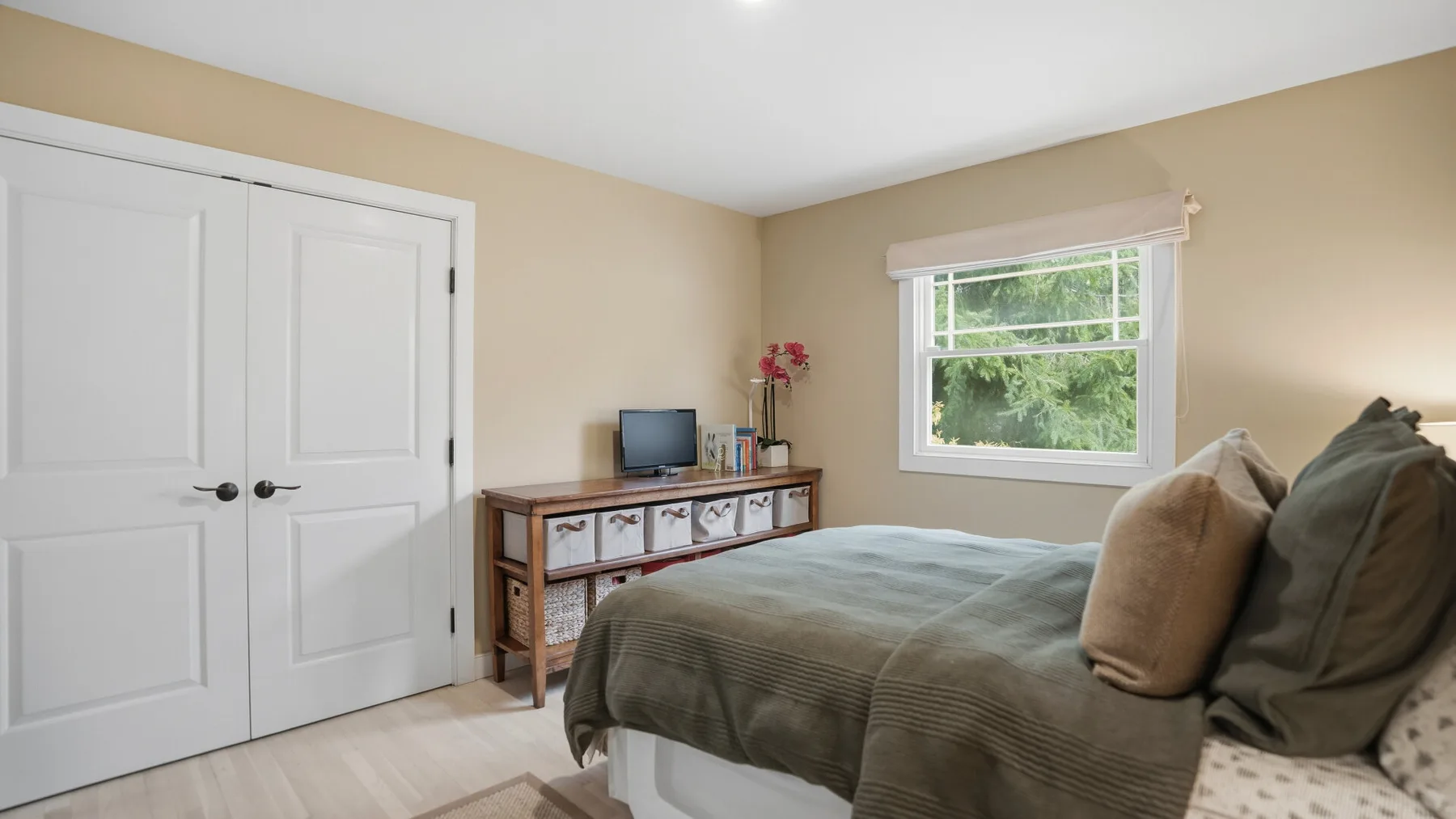 Un dormitorio con una cama, una cómoda y una ventana.