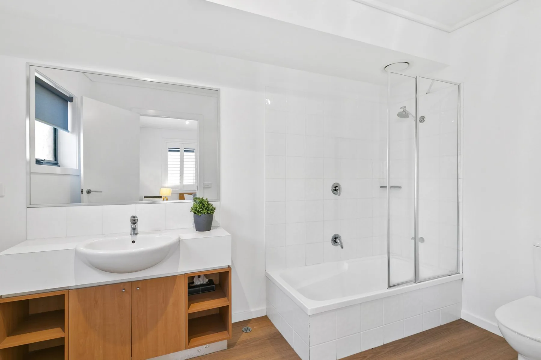 Baño luminoso con lavabo, bañera y ducha.