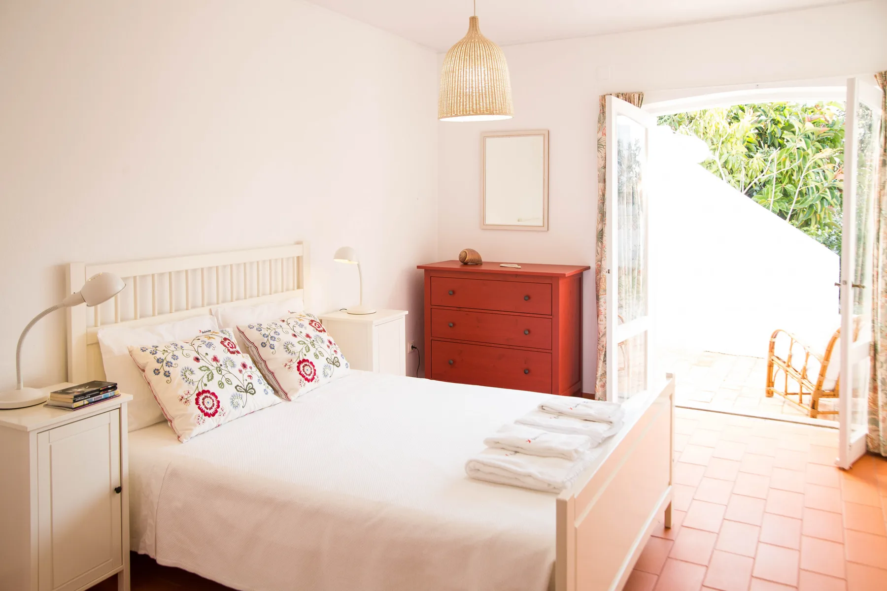 Un dormitorio luminoso con una cama y una puerta abierta a una terraza.