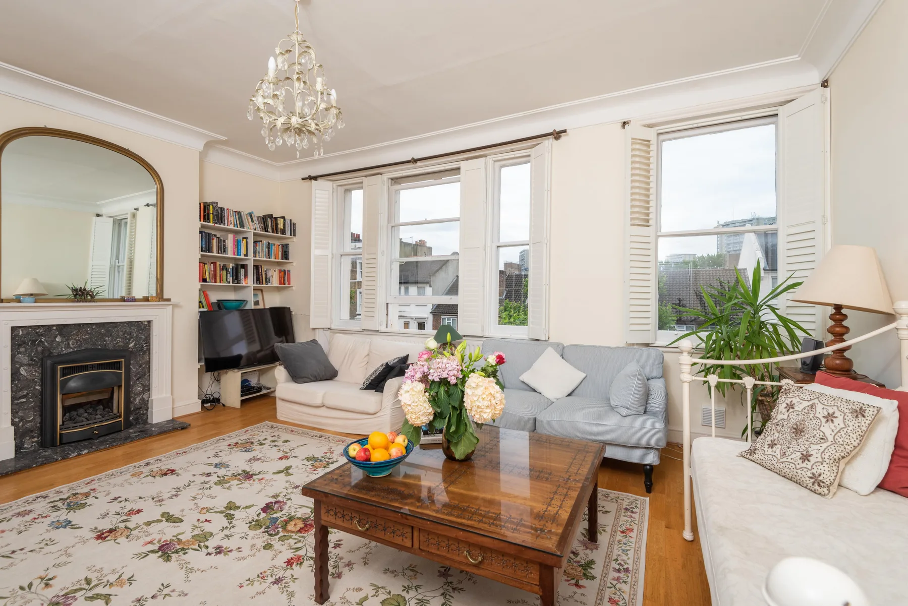 A bright living room with seating arranged around a wooden coffee table.