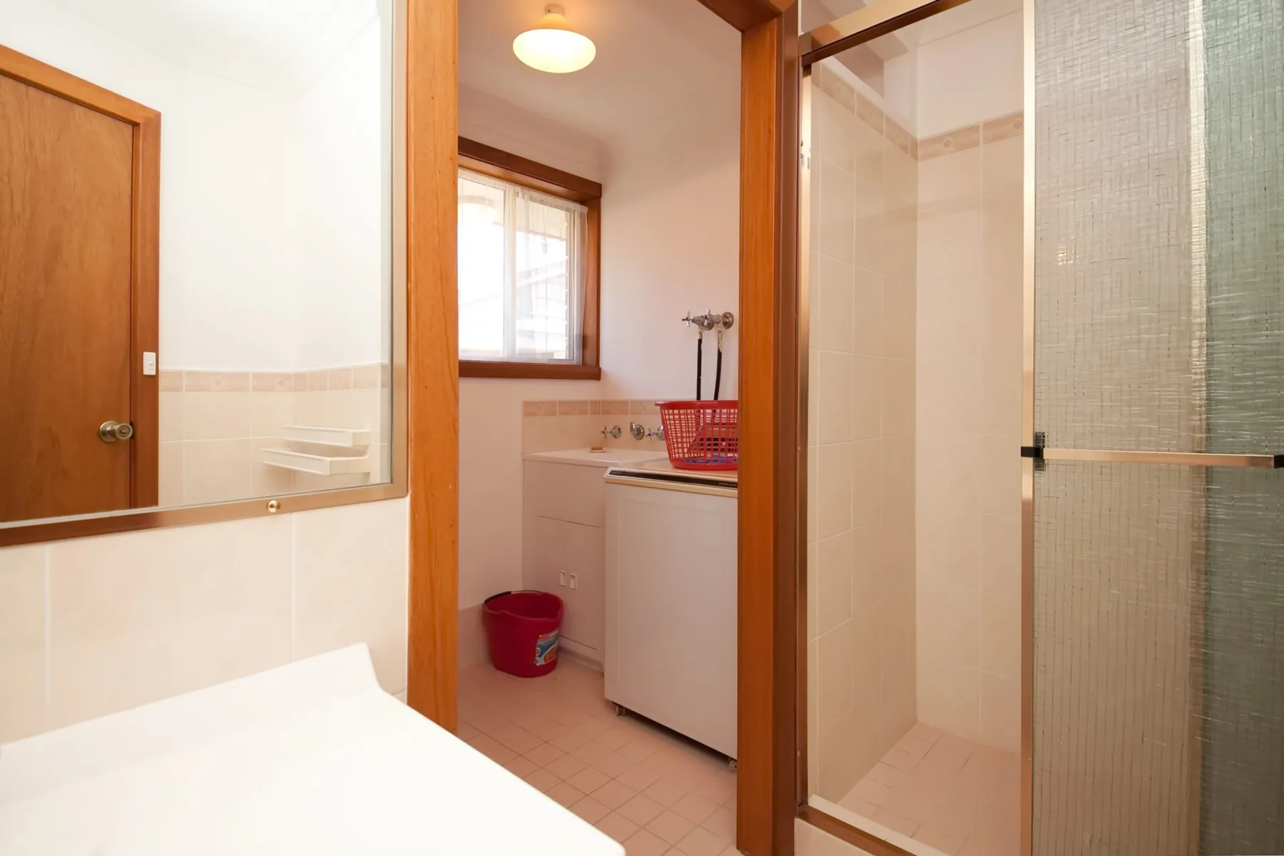 Un baño con ducha, lavabo y ventana.