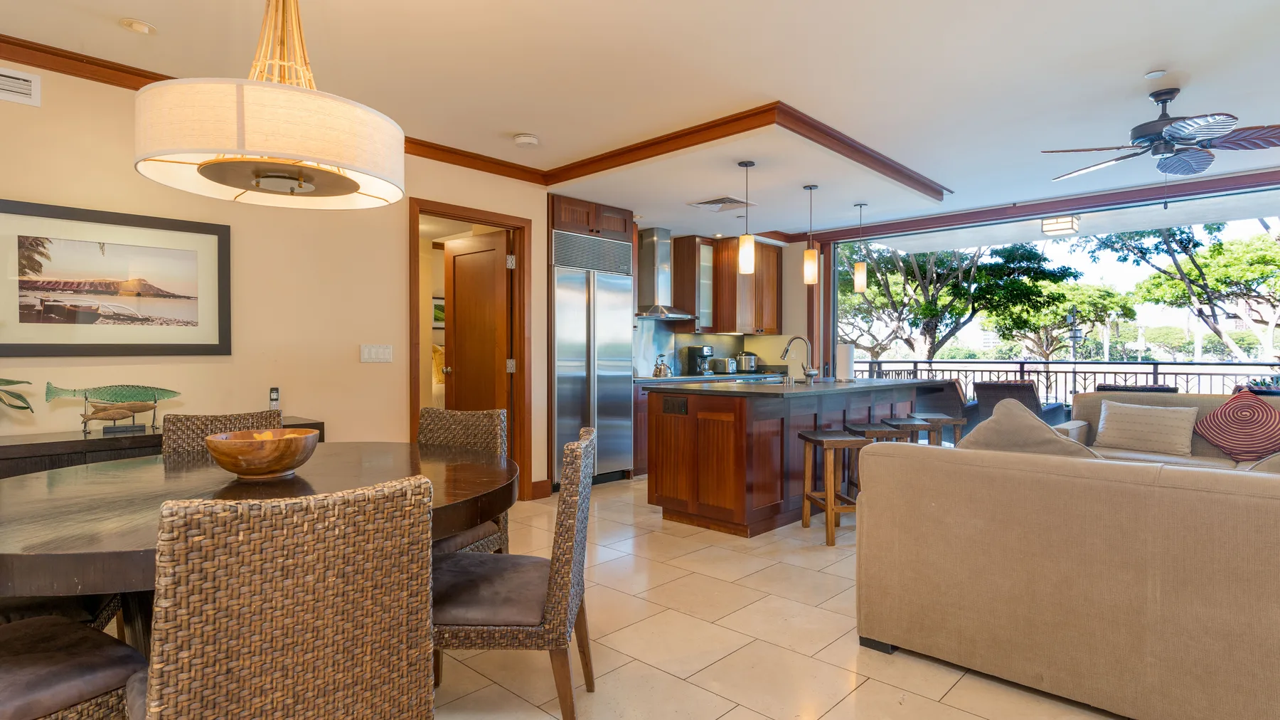 Un espacio abierto de sala y comedor con cocina y ventanas grandes.