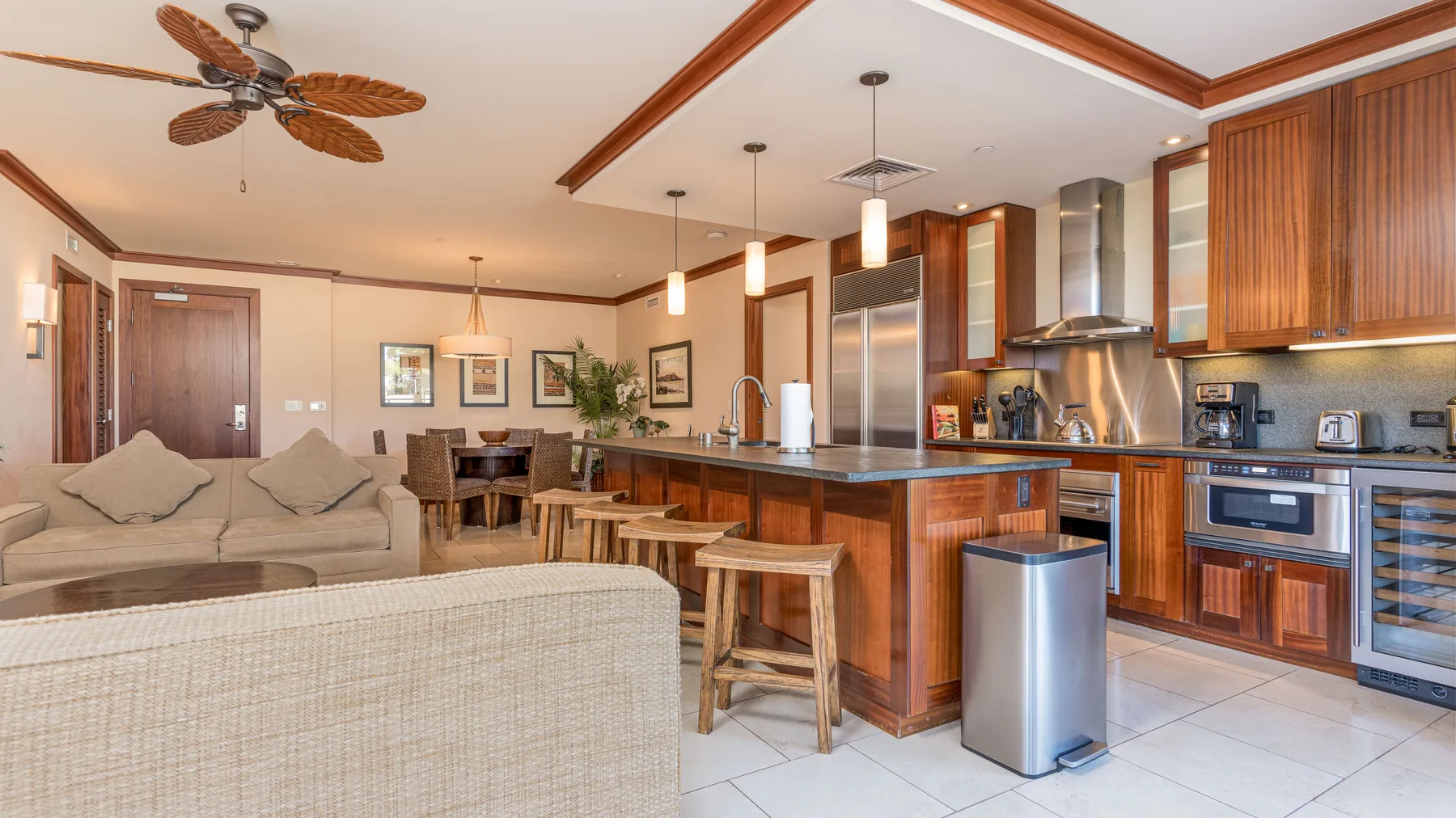 Una sala de estar y cocina de concepto abierto con isla central y asientos.
