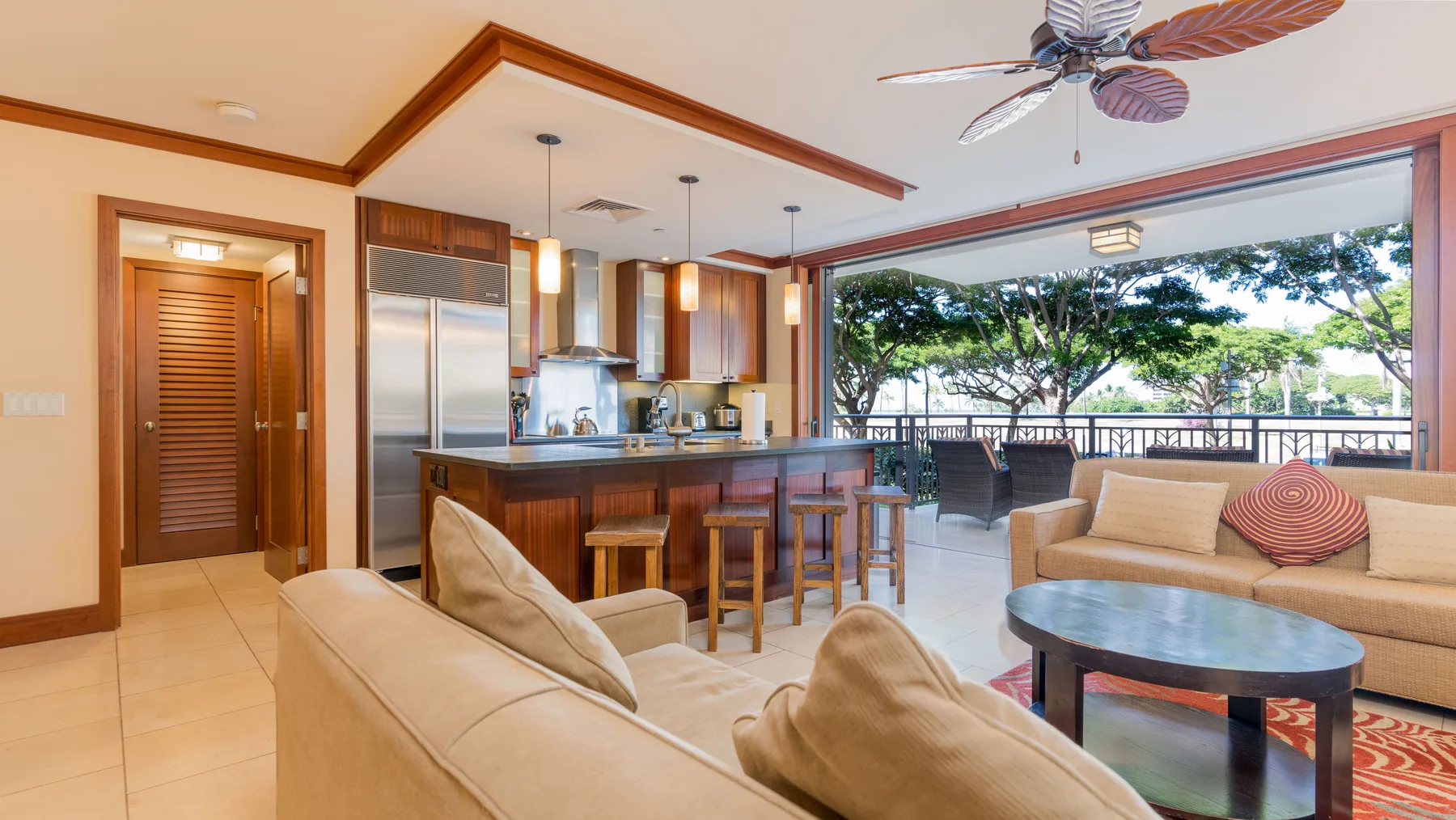 Sala de estar y cocina abiertas, con asientos junto a una amplia vista al exterior.
