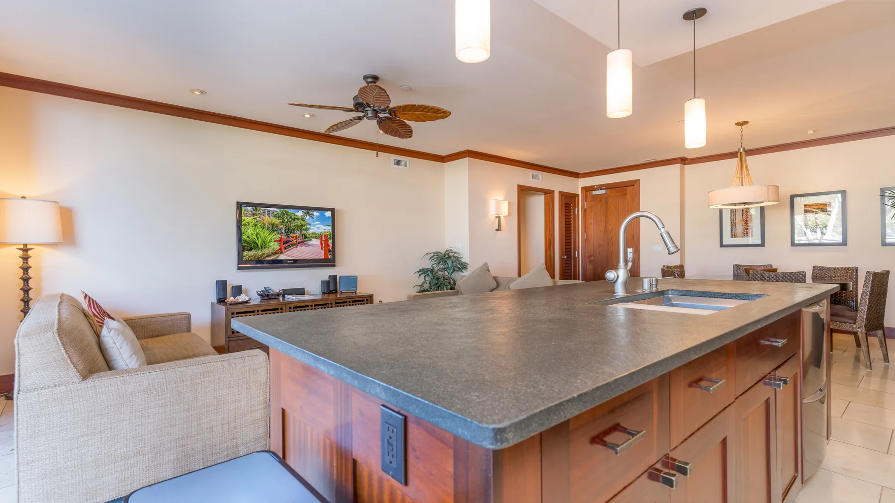 Una luminosa sala de estar y cocina de concepto abierto, con una gran isla y asientos.