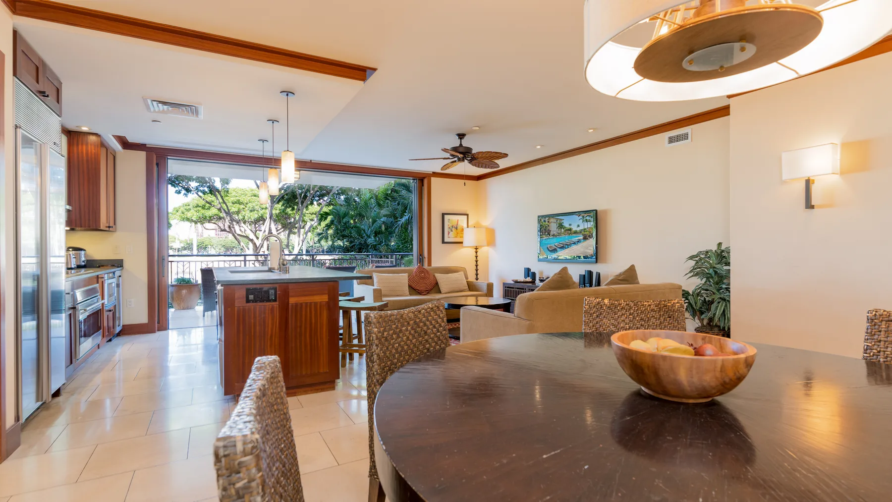 Cocina y comedor diáfanos y luminosos, con una isla de madera y grandes ventanas.