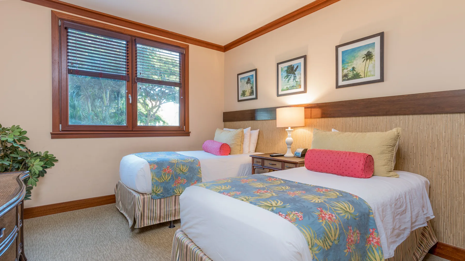 Un dormitorio con dos camas vestidas con ropa de cama floral y colorida.
