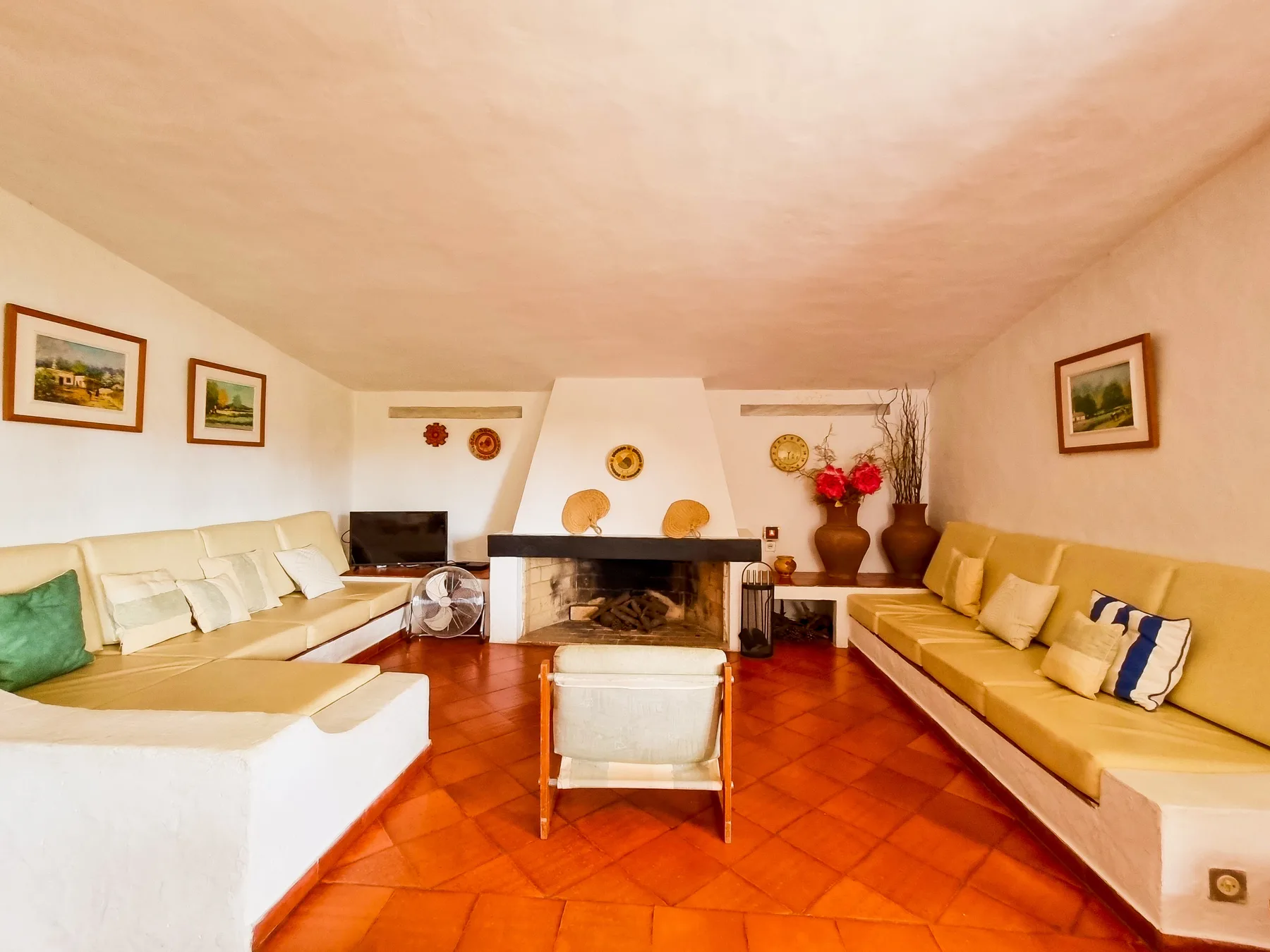 Una sala de estar con asientos dispuestos alrededor de una chimenea central.