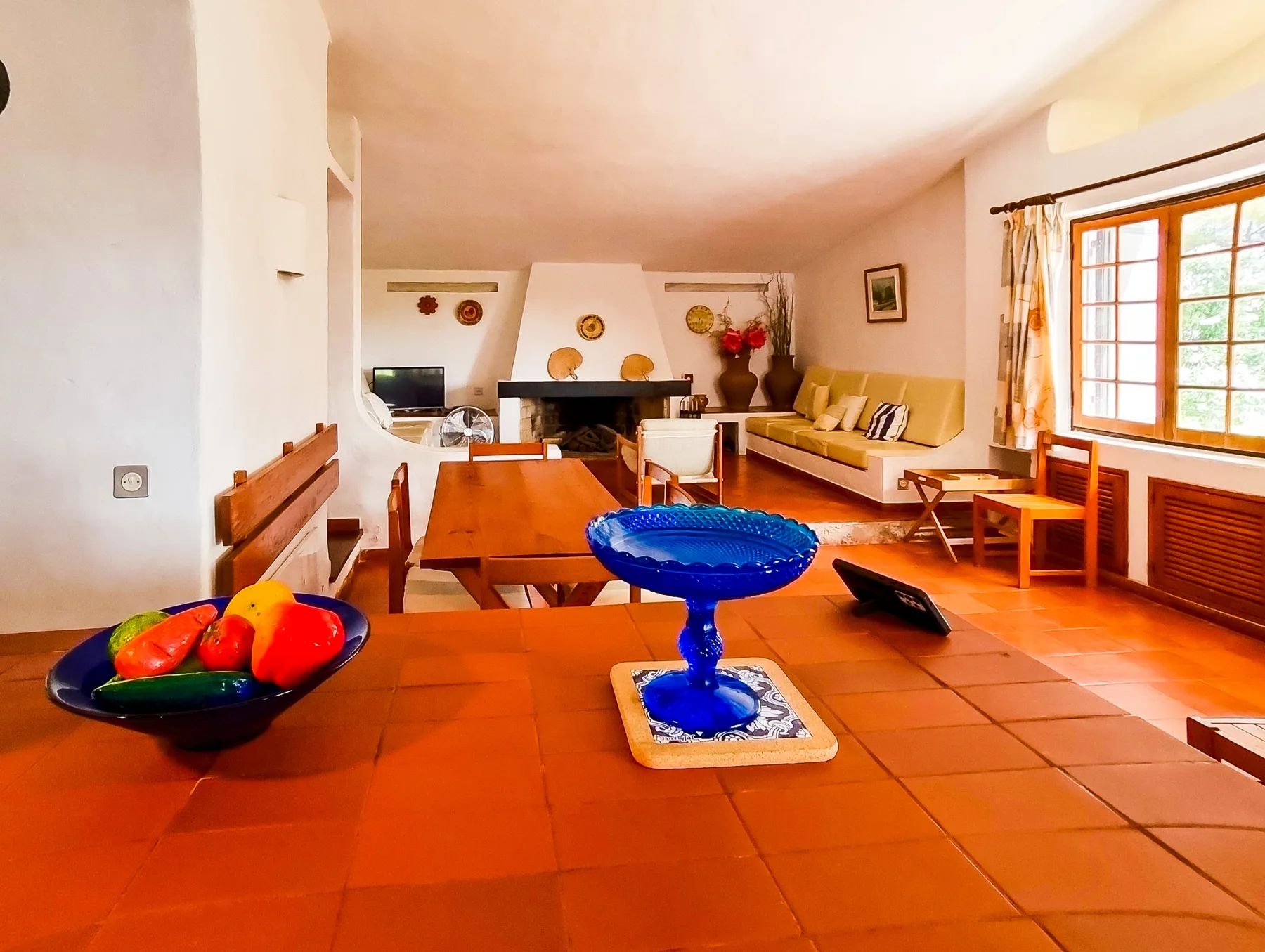Sala de estar con asientos, una mesa de centro y una ventana grande.
