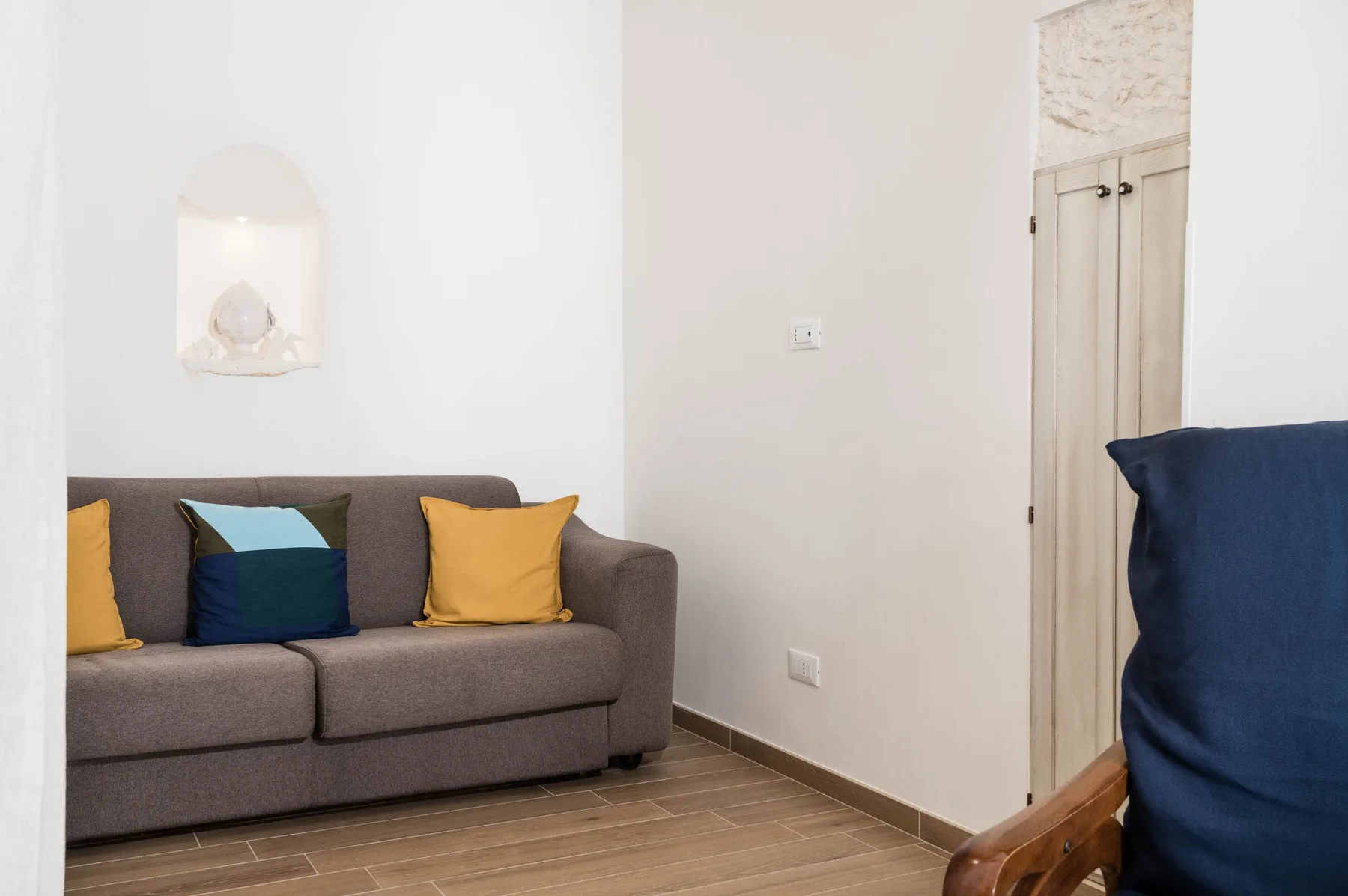 A living room with a gray sofa and colorful cushions.
