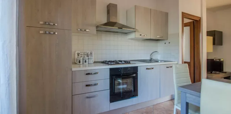 A kitchen with light cabinetry, a cooktop, and an oven.