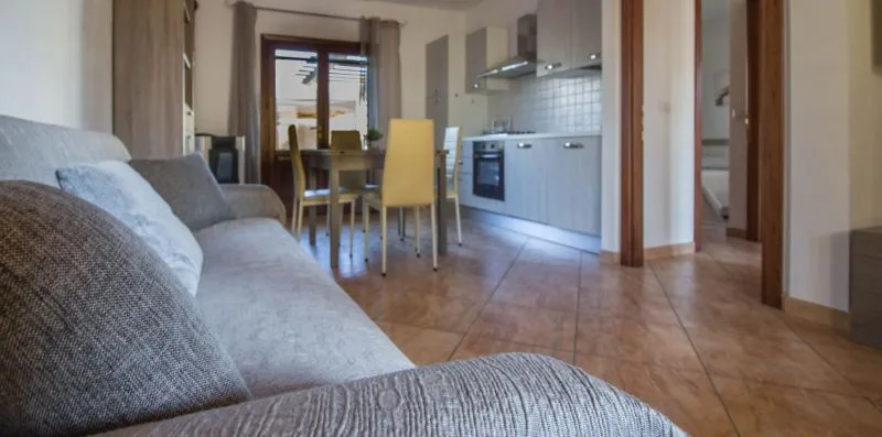 A living and dining area with seating beside a compact kitchen.